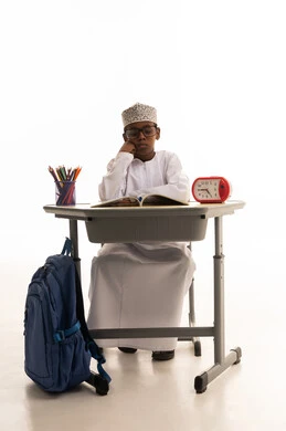 طالب عماني يدرس على مقعد دراسي بخلفية بيضاء