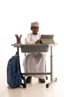 طالب عماني يستخدم جهازاً لوحياً في المدرسة