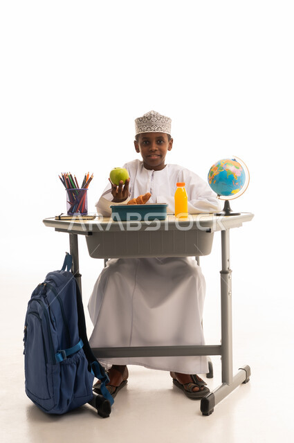 طالب عماني على مقعد الدراسة مع وجبة مدرسية