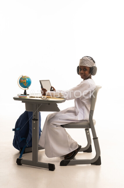 Omani Boy Student Using Tablet at School Desk