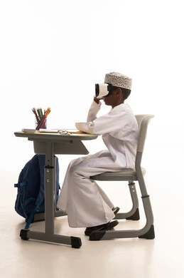 طالب عماني يستخدم نظارات الواقع الافتراضي بالمدرسة