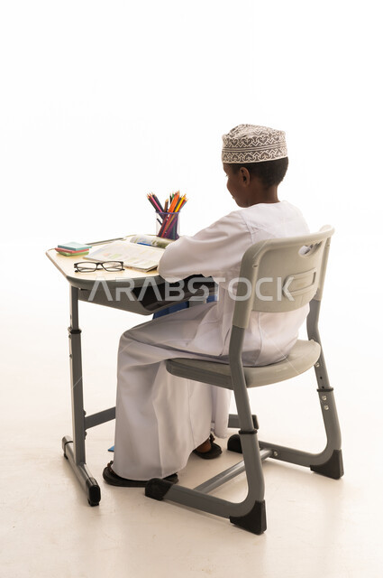 طالب عماني يجلس على مقعد دراسي في الاستوديو