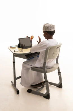Omani Boy Using Tablet for Online Learning at Desk