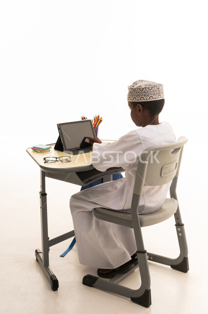 طالب مدرسي عماني يستخدم الجهاز اللوحي للتعلم الرقمي