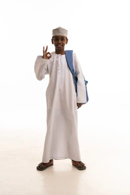 طالب مدرسي عماني بالزي التقليدي يحمل حقيبة ظهر زرقاء