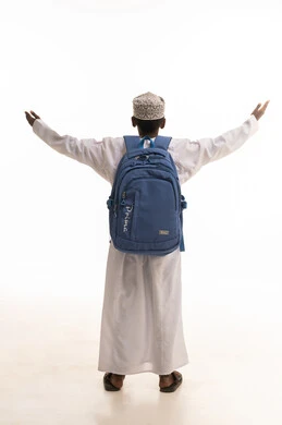 Omani Boy in Traditional Dress with Blue Backpack
