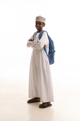 طالب عماني بالزي التقليدي مع حقيبة مدرسية زرقاء