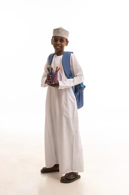 طفل عماني بحقيبة مدرسية وأقلام ملونة