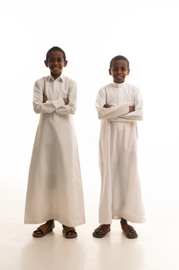 أطفال سعوديون بالثوب الأبيض التقليدي بخلفية بيضاء