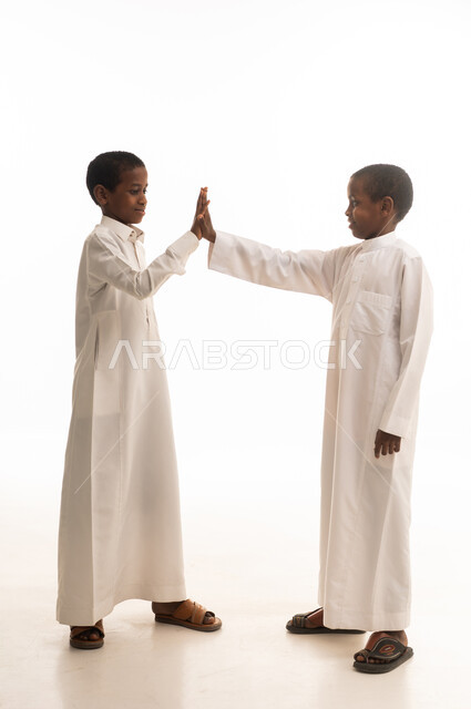 Saudi Boys in Traditional Thobes Giving High Five