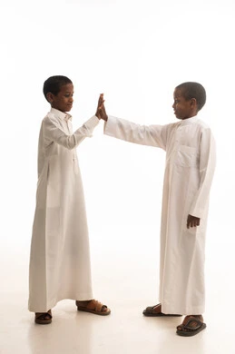 أطفال سعوديون بالثوب التقليدي يتبادلون التحية