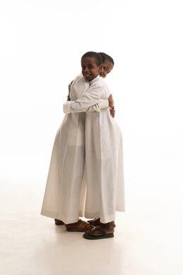 أطفال يرتدون الثوب التقليدي في وضعية عناق