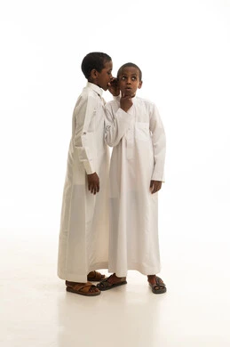 طفلان سعوديان يرتديان الثوب التقليدي يتهامسان