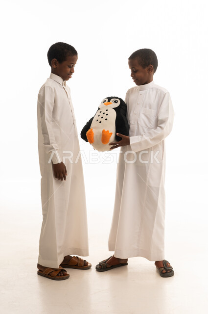 Saudi Boys in Thobes Holding Plush Toy on White Background
