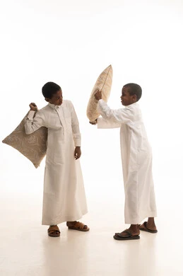 أطفال سعوديون يلعبون بالوسائد بالثياب البيضاء