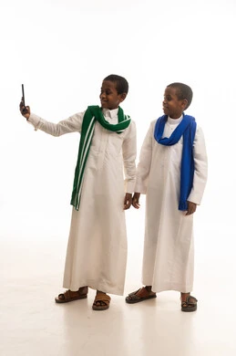 أطفال سعوديون بالثوب التقليدي يستخدمون الهاتف الذكي