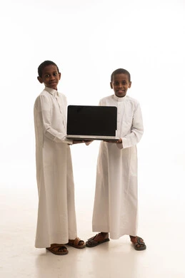 أولاد سعوديون يحملون كمبيوتر محمول في الاستوديو