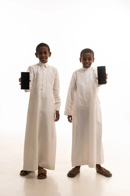 Saudi Boys in Traditional Thobes Holding Smartphones