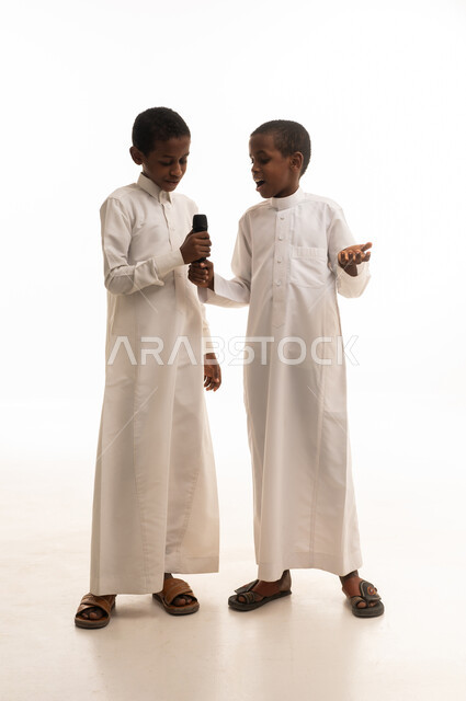 Saudi Boys in Traditional Thobes Holding Microphone