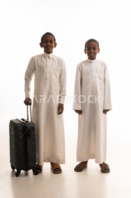 أطفال سعوديون بالثوب التقليدي مع حقيبة سفر