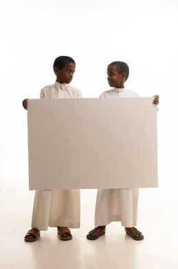 أطفال سعوديون يحملون لوحة بيضاء فارغة في الاستوديو