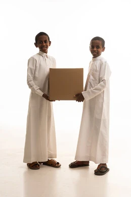 أطفال سعوديون يحملون صندوق كرتوني في استوديو