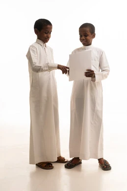 أطفال سعوديون بالثوب التقليدي يحملون ورقة بيضاء