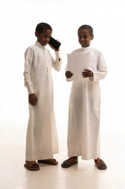 أطفال سعوديون بالثياب التقليدية مع هاتف ذكي