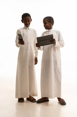 أطفال سعوديون بالثوب التقليدي يستخدمون أجهزة رقمية