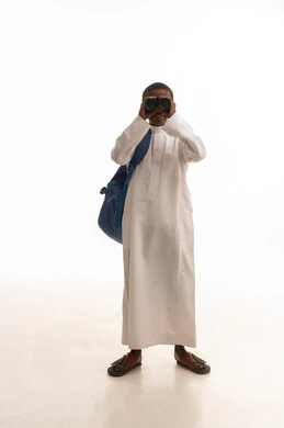 طفل سعودي بالثوب التقليدي ينظر عبر المنظار