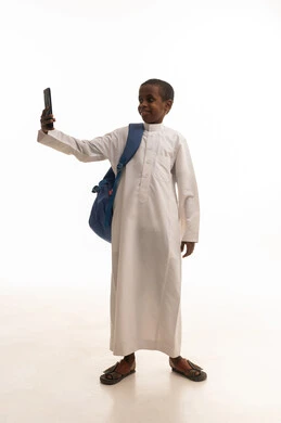 طفل سعودي بالثوب يلتقط سيلفي بالهاتف الذكي