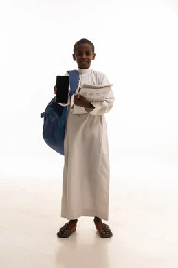 طالب سعودي يحمل هاتف ذكي وحقيبة مدرسية