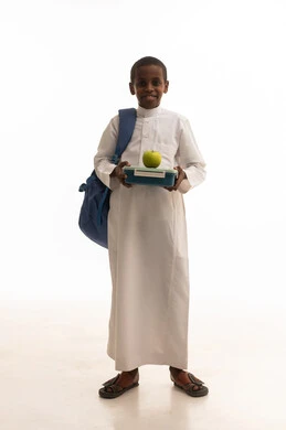 طالب سعودي بالثوب يحمل صندوق غداء وتفاحة