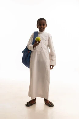 طالب سعودي مع حقيبة مدرسية وتفاحة خضراء