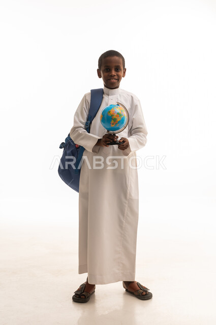 طالب سعودي يحمل مجسم الكرة الأرضية بخلفية بيضاء