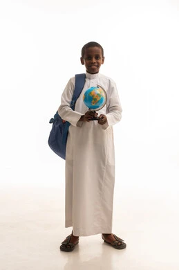 طالب سعودي يحمل مجسم الكرة الأرضية بخلفية بيضاء