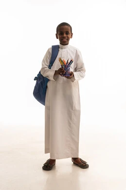 طالب سعودي بالثوب يحمل حقيبة مدرسية وأقلام