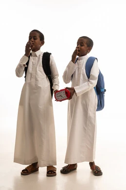 طلاب سعوديون يشعرون بالنعاس مع حقائب مدرسية ومنبه