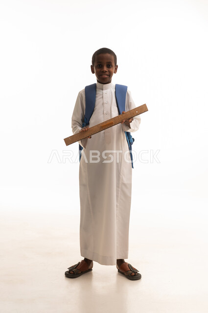 Saudi School Boy in Thobe Holding a Wooden Ruler