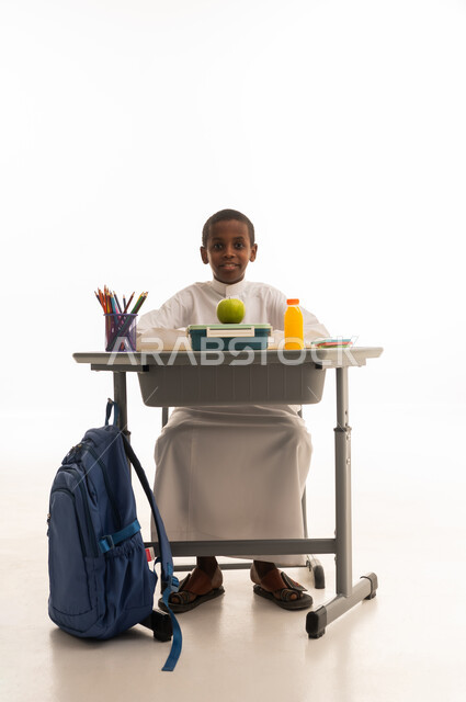 Saudi Schoolboy at Desk with Lunchbox and Backpack