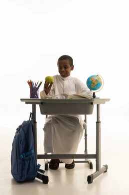 طالب سعودي على مقعد الدراسة مع مستلزمات مدرسية