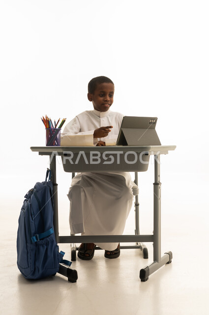 Saudi Boy Student Using Digital Tablet at School Desk