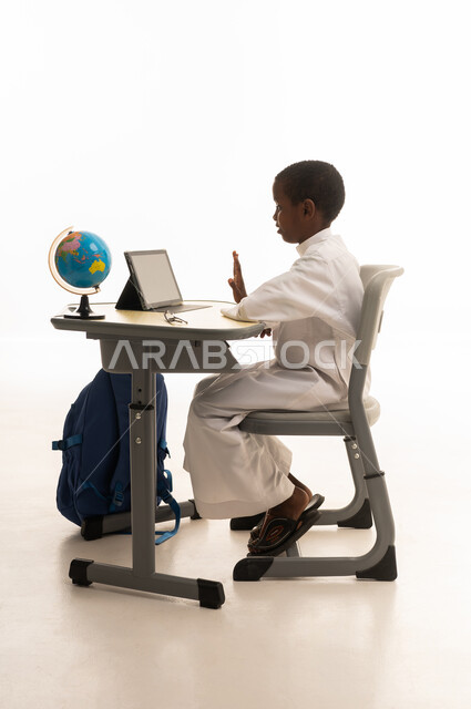 طالب سعودي بالثوب الأبيض يستخدم جهاز لوحي