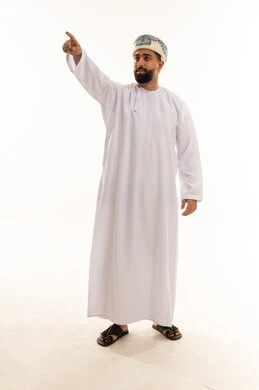 رجل عماني بالزي التقليدي يشير بيده في الاستوديو