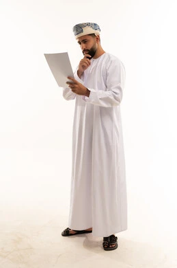 Omani Man in Traditional Dress Reviewing Document