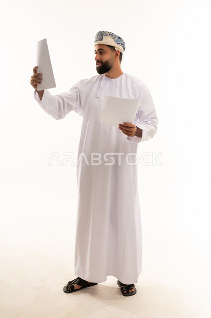 Omani Man Reviewing Documents on White Background
