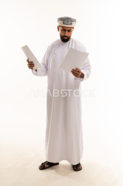 رجل عُماني يقرأ مستندات بالزي التقليدي