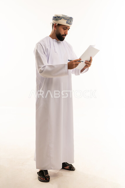 رجل عماني يقرأ مستند بالزي التقليدي العماني
