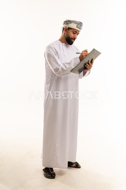 رجل عماني يكتب على لوحة ملاحظات في استوديو
