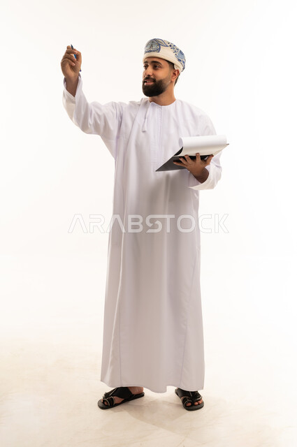 رجل عماني بالزي التقليدي يكتب على خلفية بيضاء